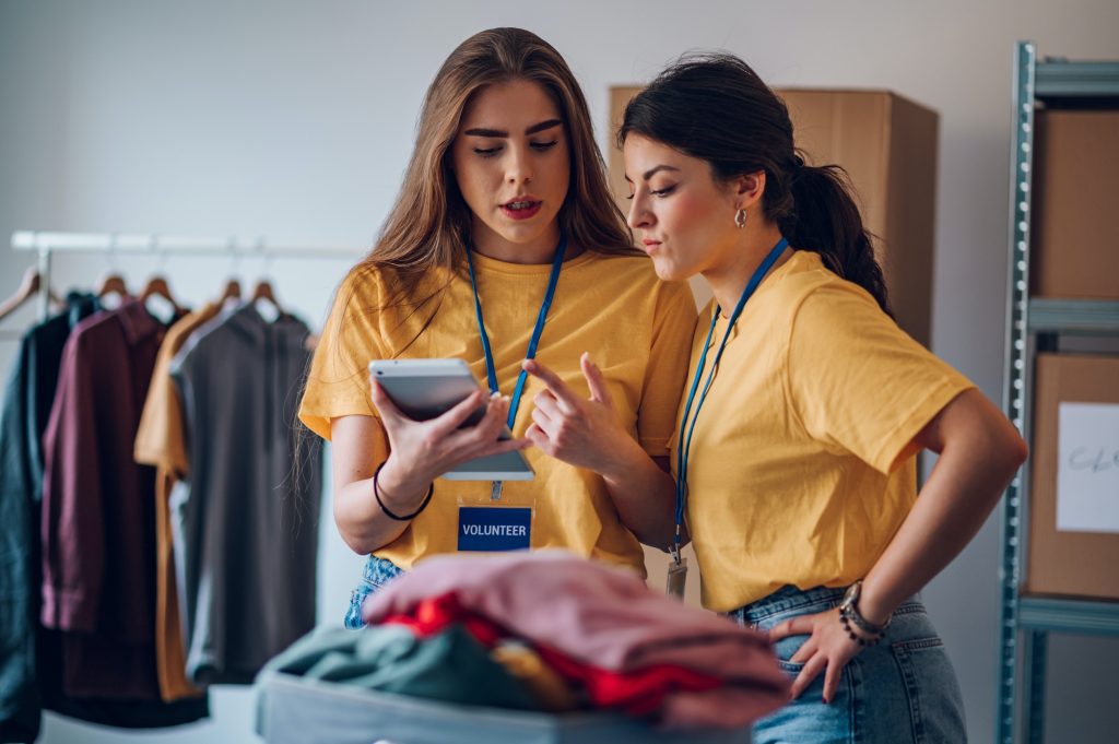 Couple of female volunteers working in community charity donation center